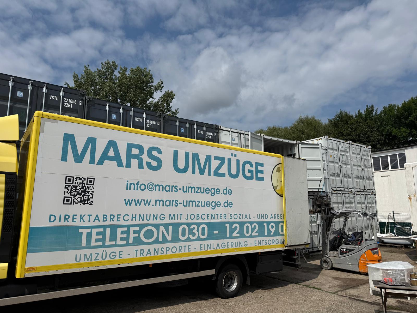 LKW von Mars Umzüge auf dem Lagerplatz vor Seecontainern für die Zwischenlagerung